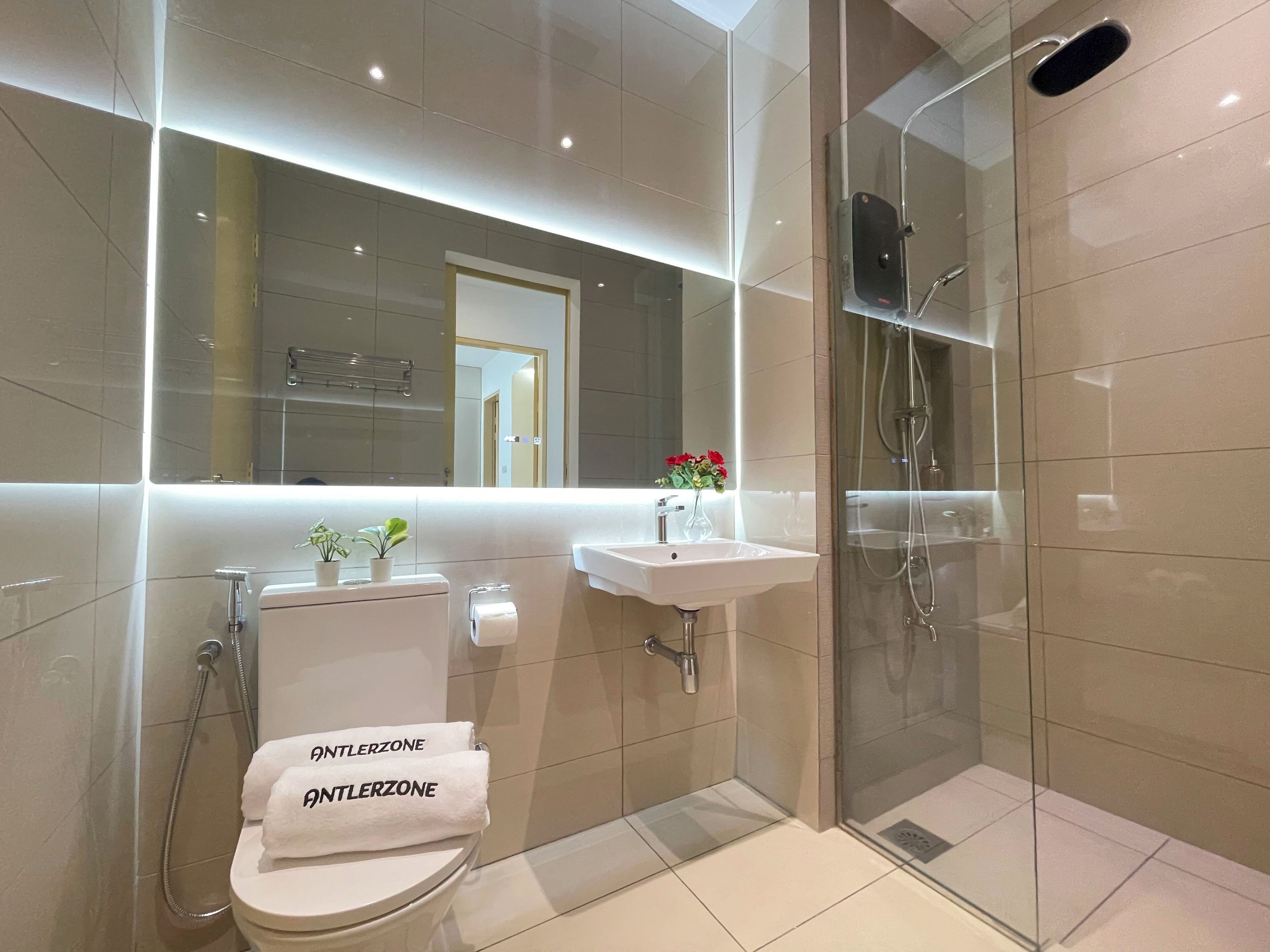 Un baño moderno con ducha de vidrio, inodoro y lavamanos.