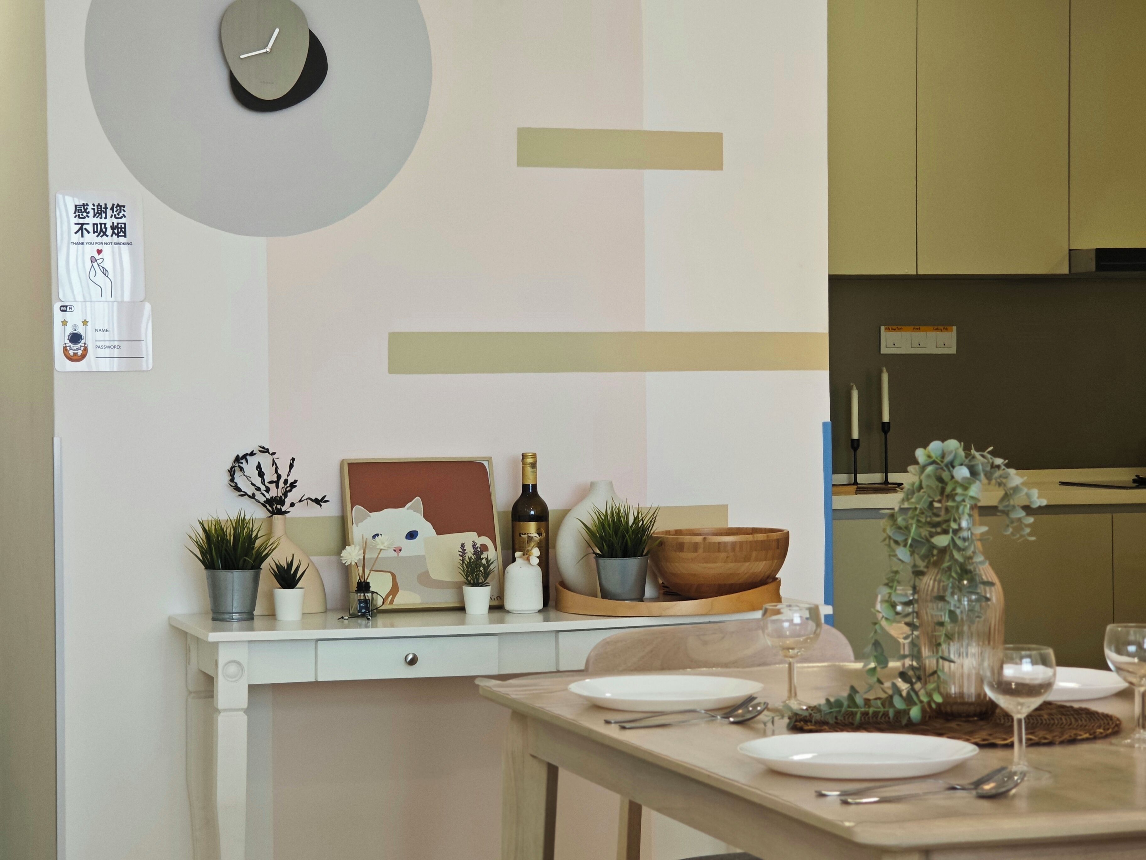 Una cocina moderna con encimera blanca, un reloj y un panel decorativo en la pared.