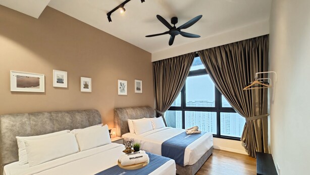 A hotel room with two beds, a ceiling fan, a large window with curtains, and artwork on the wall. - Paradigm Residence By Antlerzone (Johor Bahru)