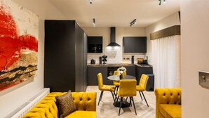 A modern living room with a yellow sofa set, a dining table with yellow chairs, and a kitchen in the background. - Home at 42 Arkles Lane (Liverpool)