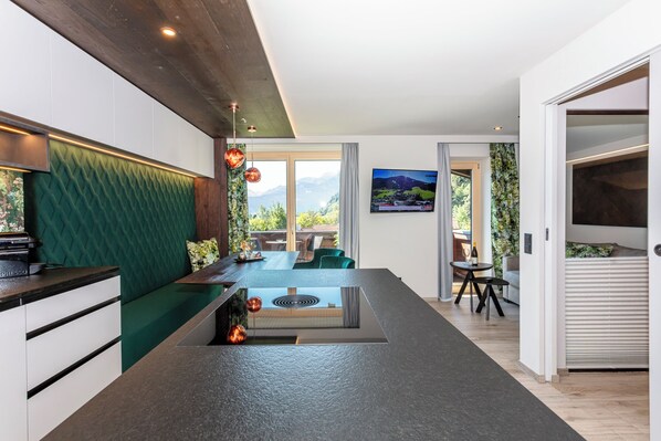 Suite Deluxe, balcón, vista a la montaña | Área de sala de estar | Televisión