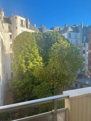 A tree in the shape of a heart, surrounded by buildings.