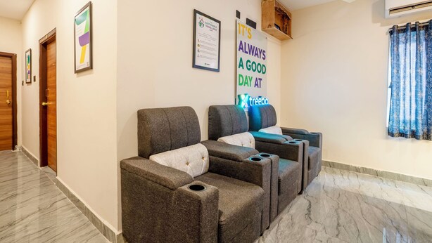 Eine Hotelhalle mit Sitzgelegenheiten, darunter Sofas und Sessel, einem Deckenventilator und einer Wand mit motivierenden Plakaten.