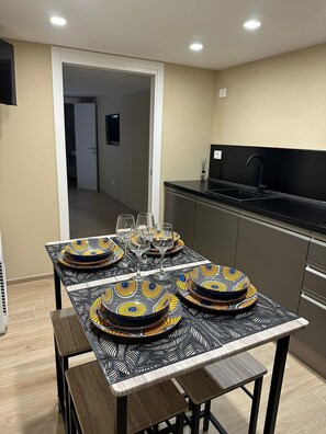A dining area with a table set for four, featuring patterned tableware and glasses. - BLESSED ELIA LOFT (Bari)