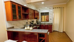 Economy Apartment, Hill View | Private kitchen | Fridge, microwave, oven, stovetop - Sand Grains Residences 008 (Entebbe)