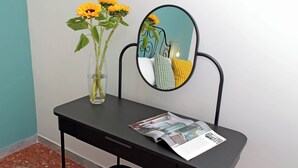 A desk with a vase of sunflowers, a mirror, and a magazine. - TM Apartment (Rome)
