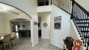 A spacious interior with a staircase, a welcome sign, and a dining area. - Spacious 5-bedroom house in peaceful Midway with WiFi, AC Close to Savannah GA  (Midway)