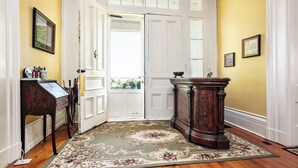 A hallway with a wooden floor, a large rug, a wooden bench, and a door with a white frame. - 7 Private Rooms, Country Setting Bourbon Trail, patio/firepit. Breakfast inc. (Springfield)