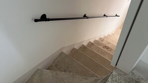 Un escalier avec une rampe et un palier.