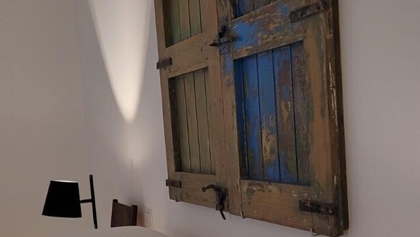 Une chambre à coucher avec un lit, une porte en bois, une lampe et une table de chevet.
