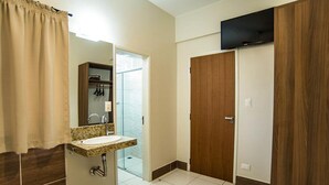 Un bagno con lavandino, specchio e doccia.