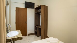Un bagno con lavandino, specchio e mobile contenitore in legno.