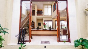 A spacious foyer with a central staircase, a reception desk, and a view into the upper floor.