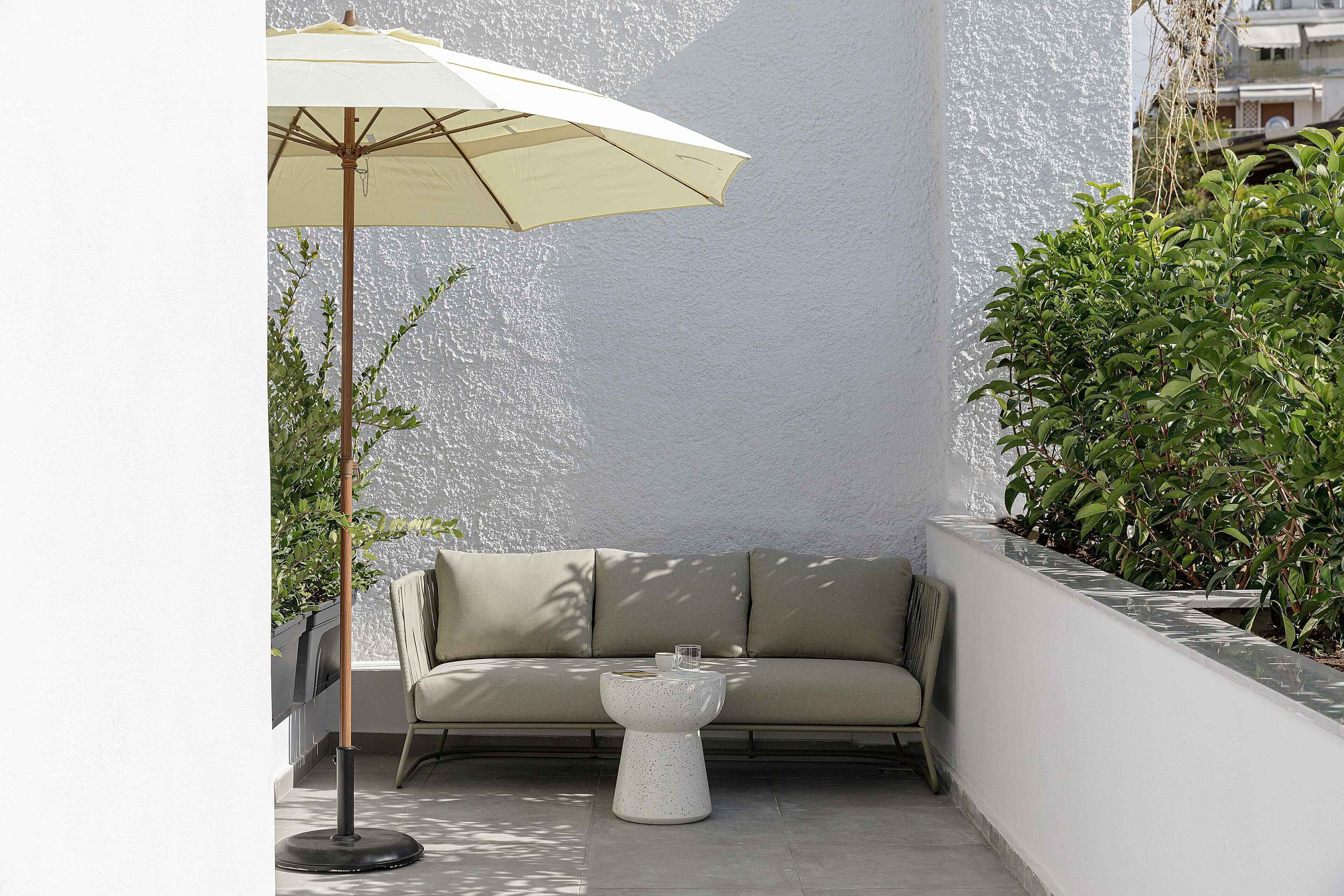 A corner seating area with a sofa, a small table, and an umbrella.