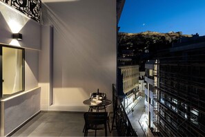 A balcony with a table and chairs, a view of the cityscape, and a building with scaffolding. - master Plaka (Athens)