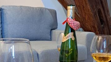 Une table en bois avec une bouteille de vin, des verres et des assiettes de bretzels.
