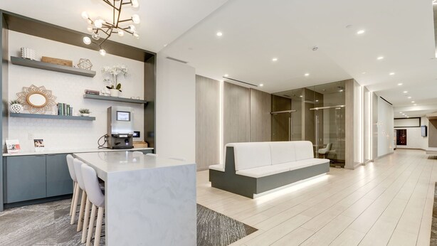 A modern kitchen with a central island, built-in seating, and a dining area. - Elegant 2BR Apartment Minutes From DC (Arlington)
