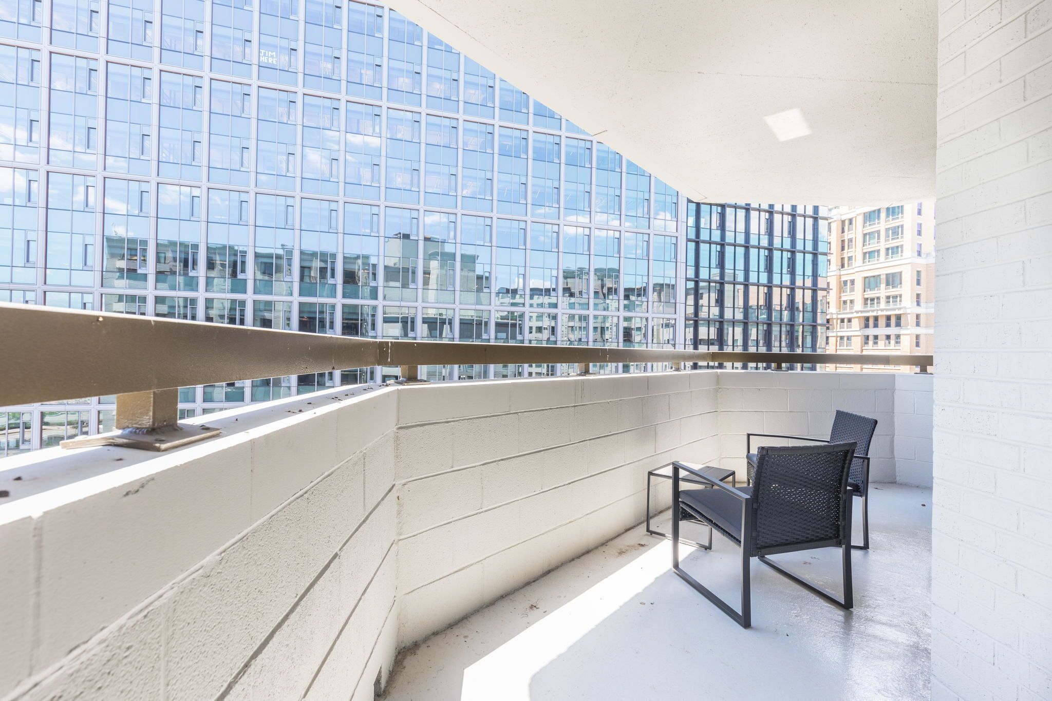 Ein Balkon mit Blick auf ein modernes Gebäude mit Glasfassade.