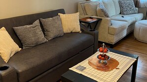 A living room with a dark brown sofa, a light-colored sofa, and a coffee table with a placemat. - Charming 3-bedroom 2 bath farmhouse surrounded by Corodus State Park in Hanover. (Hanover)