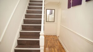 Eine Treppe mit Holzbodenstufen und weißen Spindeln.