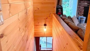 A wooden interior with a staircase leading to a loft area, a window with a view, and a fireplace. - Pet Friendly Ski House, Game Rm, 4 Mins to Mt Snow (Dover)