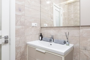 Bathroom features a sink, mirror, and towel rack with two towels.