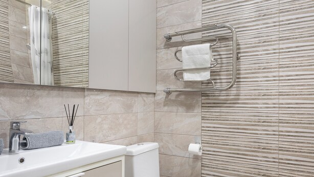 A modern bathroom with a white vanity, a toilet, and a towel rack. - Apartments in the complex Vogue (Minsk)