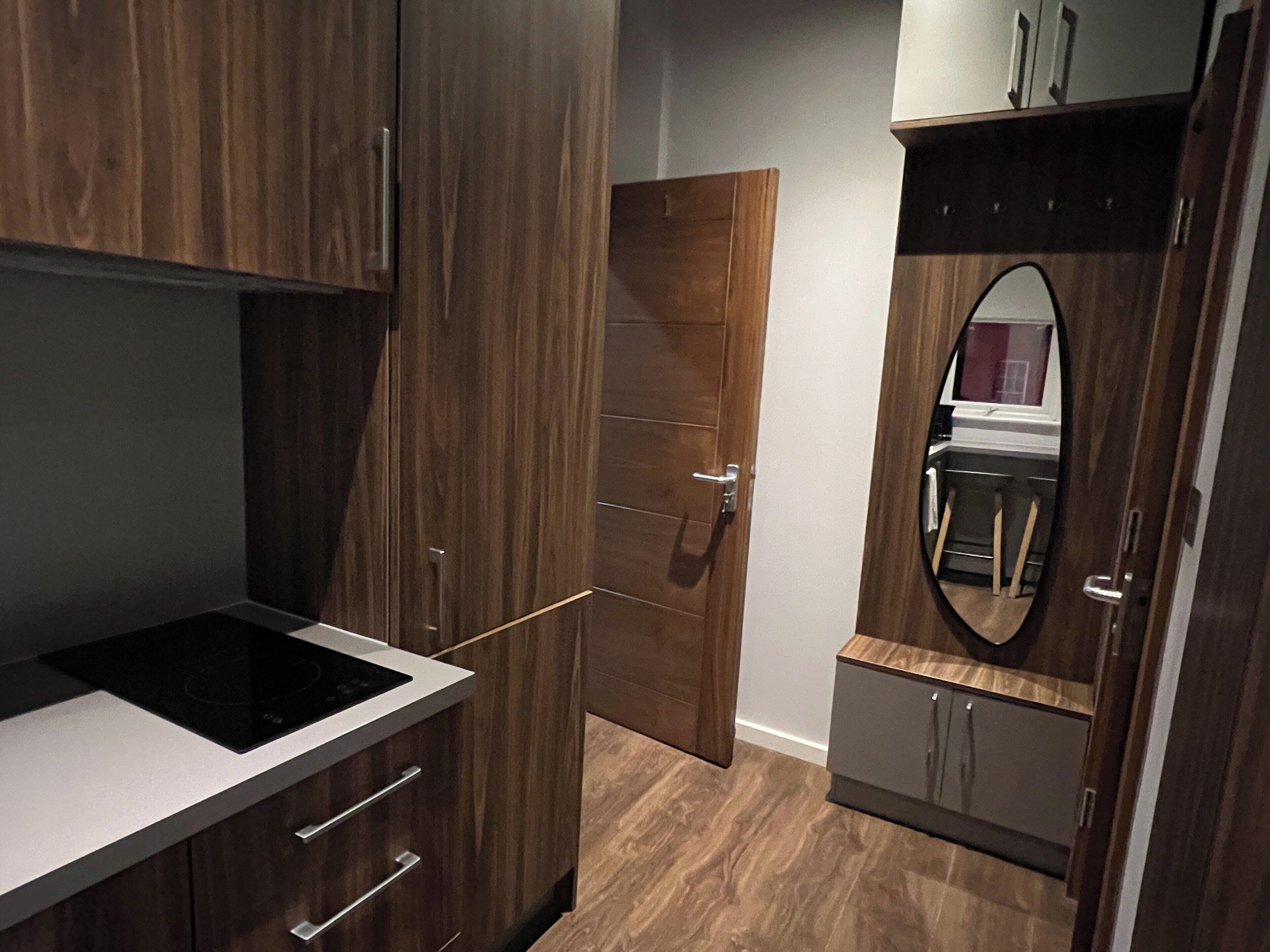 A modern kitchen with wooden cabinets, a built-in oven, and a countertop.