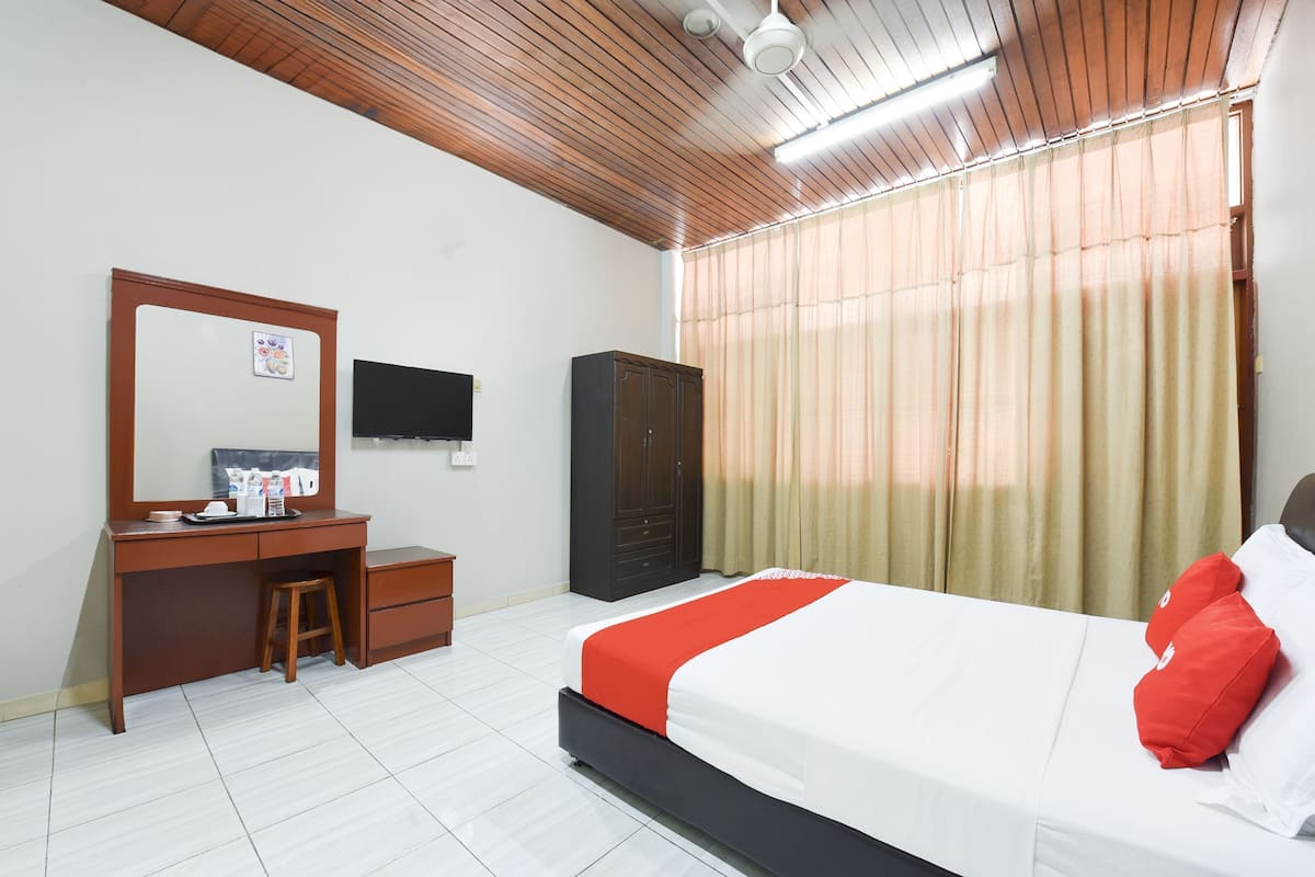 Une chambre d’hôtel équipée d’un lit, d’un bureau, d’une armoire et d’un téléviseur.