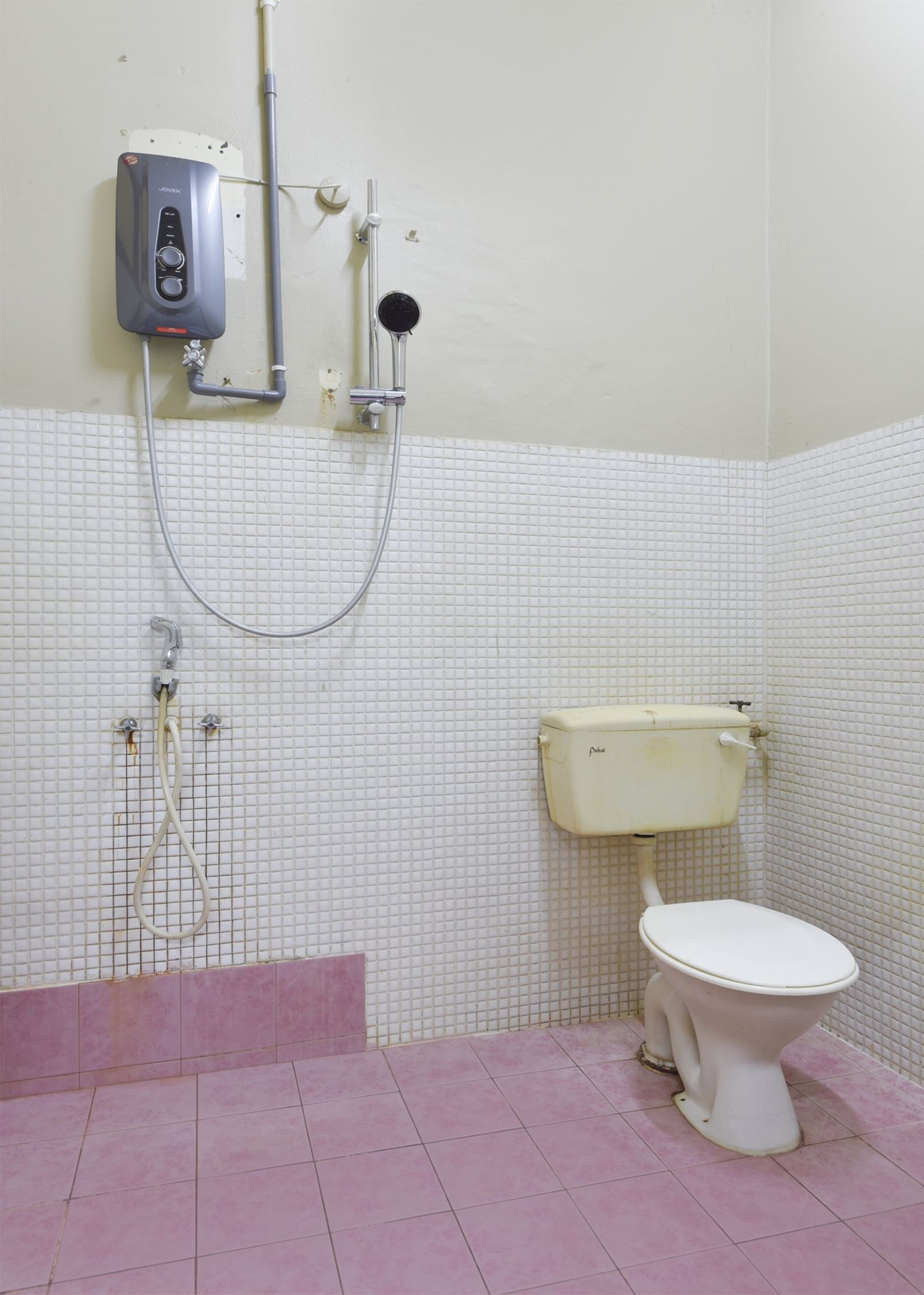A bathroom with a toilet, a shower, and a water heater.