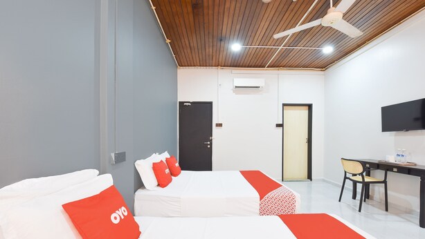 A modern hotel room with two beds, a desk, a chair, and a TV. - OYO 91052 Hotel Kenangan (Kuala Terengganu)