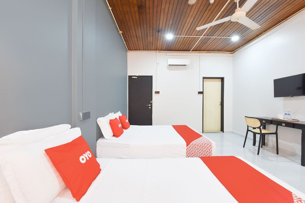 Une chambre d’hôtel moderne équipée de deux lits, d’un bureau, d’une chaise et d’un téléviseur.