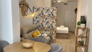 Un comedor moderno con una mesa redonda de madera, sillas tapizadas de color gris y una alfombra estampada.