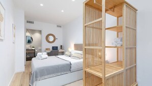 Une chambre à coucher moderne avec un lit, une table de chevet et une armoire en bois.