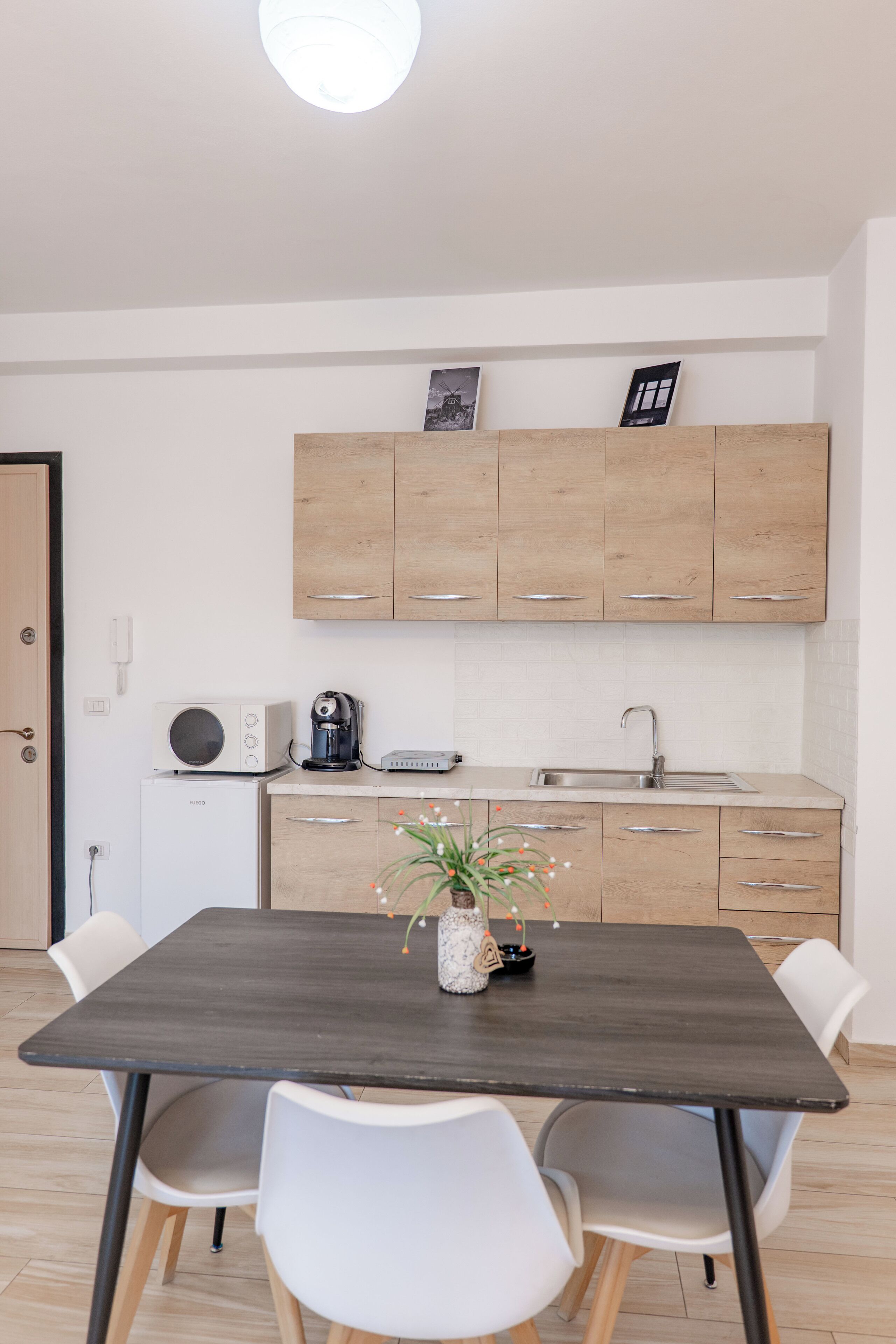 A modern kitchen with wooden cabinets, a microwave, a coffee maker, and a sink.