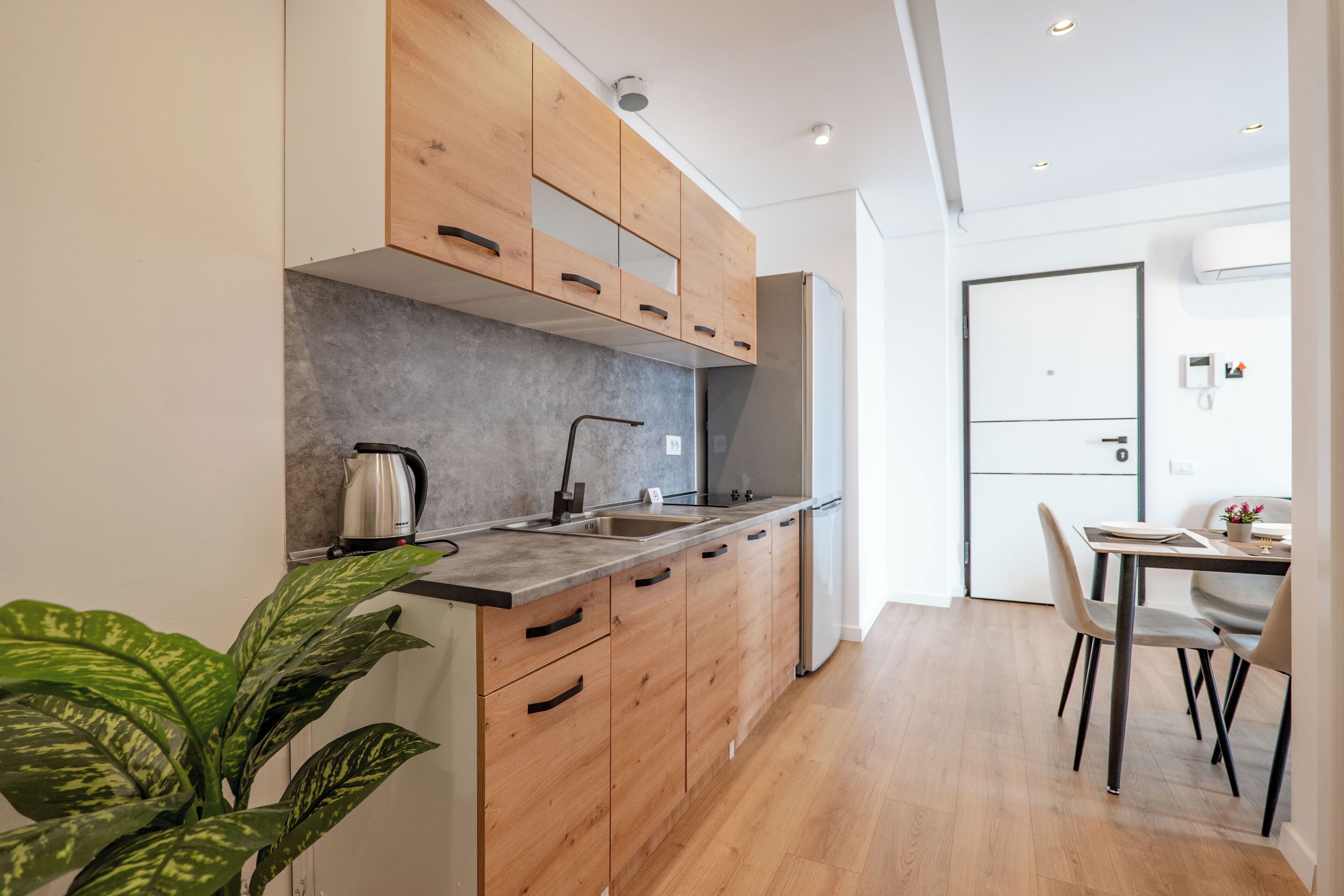 A modern kitchen with wooden cabinets, a stainless steel sink, and a built-in oven.
