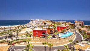 Ein Resort mit Pool, Palmen und Blick auf den Ozean.
