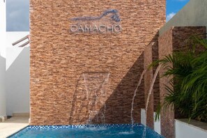 Eine Ziegelwand mit dem Schriftzug "CAMACHO" und einer Silhouetten-Darstellung eines Pferdes.