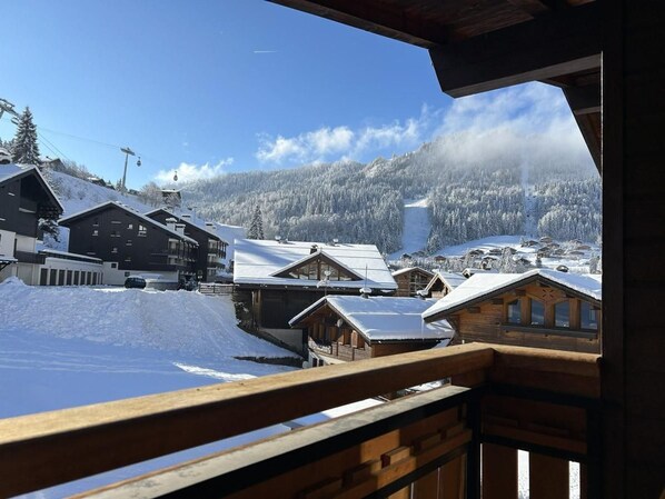 A snowy mountain village with wooden buildings and a clear sky.