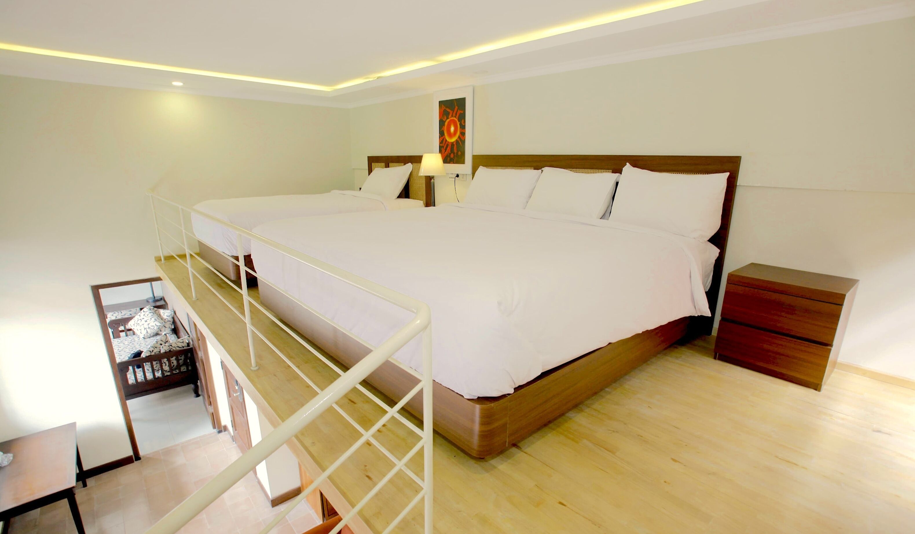 A spacious bedroom with a large bed, wooden headboard, and a nightstand.