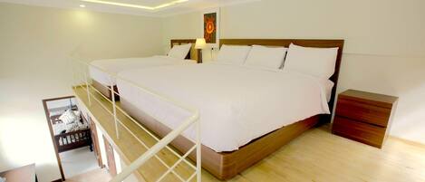 A spacious bedroom with a large bed, wooden headboard, and a nightstand.