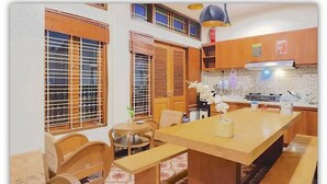 Una cocina compacta con armarios de madera, una isla central y un comedor con sillas y un banco.