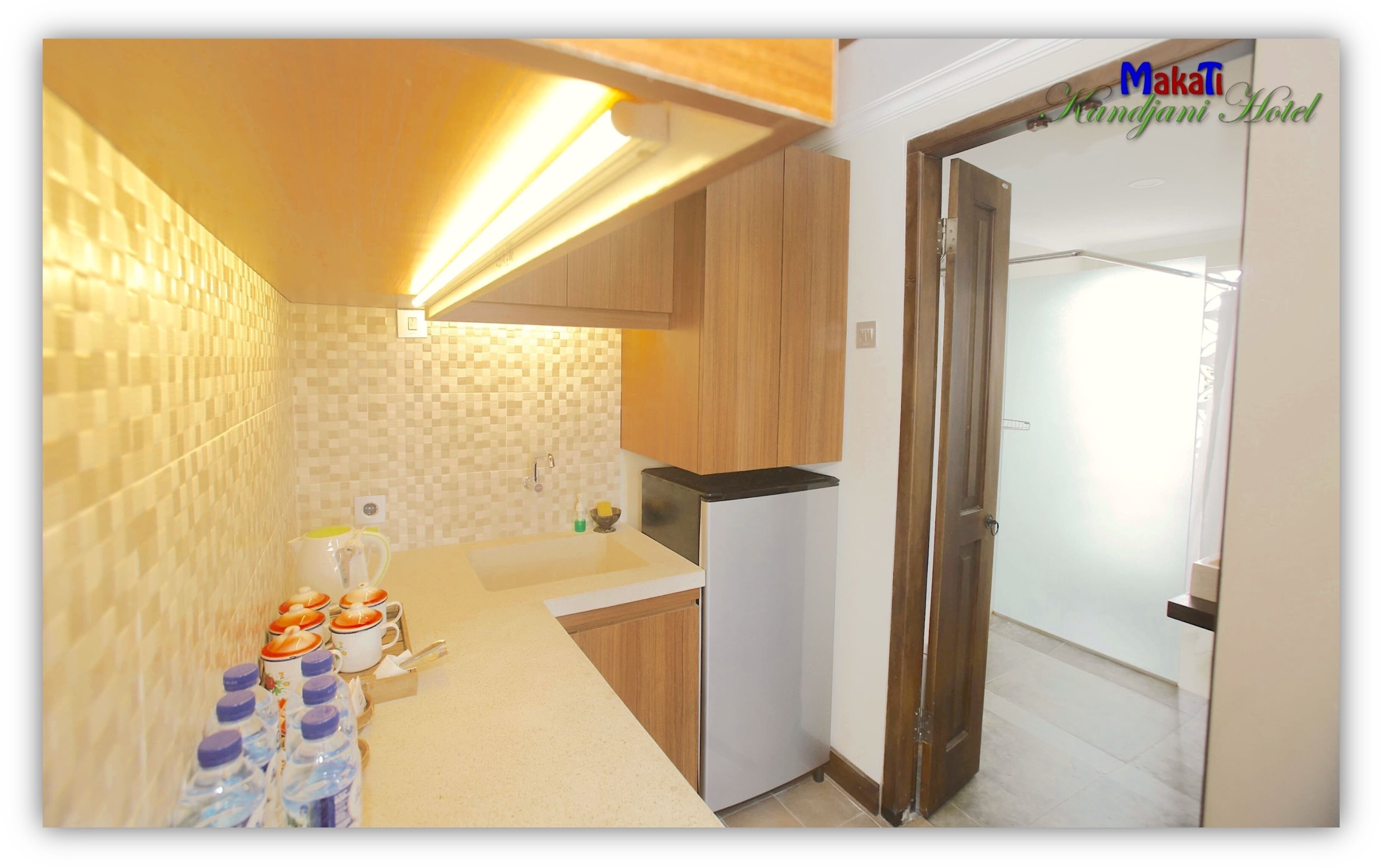 Une cuisine moderne avec des meubles en bois, un réfrigérateur en acier inoxydable et un pare-feu en carreaux.