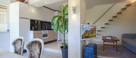 A modern apartment with a kitchen, dining area, and living room.