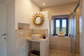 Een moderne badkamer met een grote spiegel, een wastafel en een douche.
