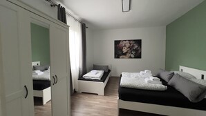 Ein Schlafzimmer mit zwei Betten, einem Kleiderschrank und einem Bild an der Wand.