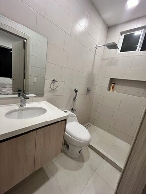 Een douche, handdoeken, zeep, shampoo