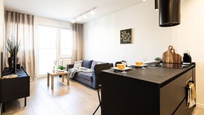 A modern living room with a sofa, a coffee table, and a dining area with a counter. - Pueblo Spacerkiem Brd na Stary Rynek Gara (Bydgoszcz)