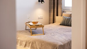 A bedroom with a bed, a bedside table with a bowl of cereal and a glass, and a wall-mounted lamp. - Pueblo Spacerkiem Brd na Stary Rynek Gara (Bydgoszcz)