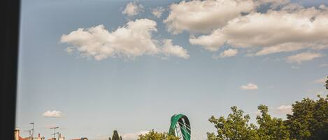 Vista de un puente con un arco verde y un cielo despejado con nubes.